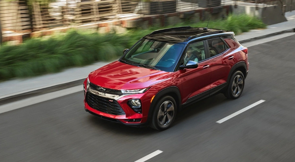 A red 2021 Chevy Trailblazer driving past blurred greenery.