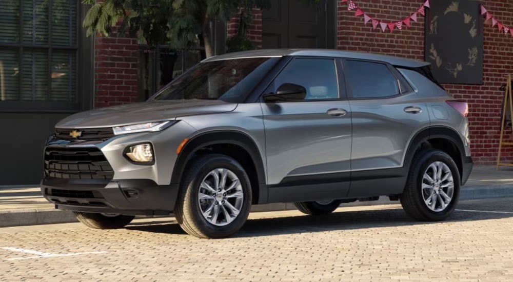 A silver 2023 Chevy Trailblazer is shown parked in front of a brick building.