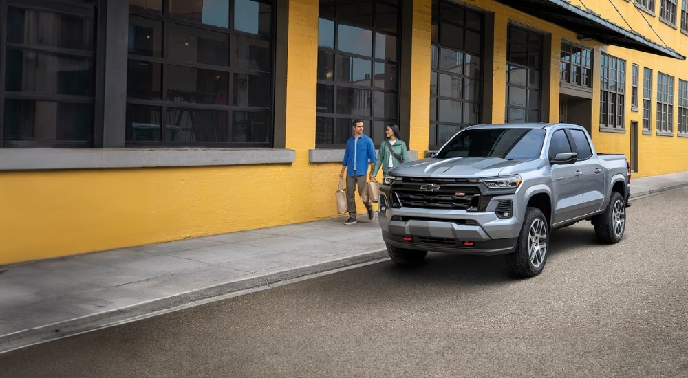 A silver 2024 Chevy Colorado Z71 is shown parked on a city street.
