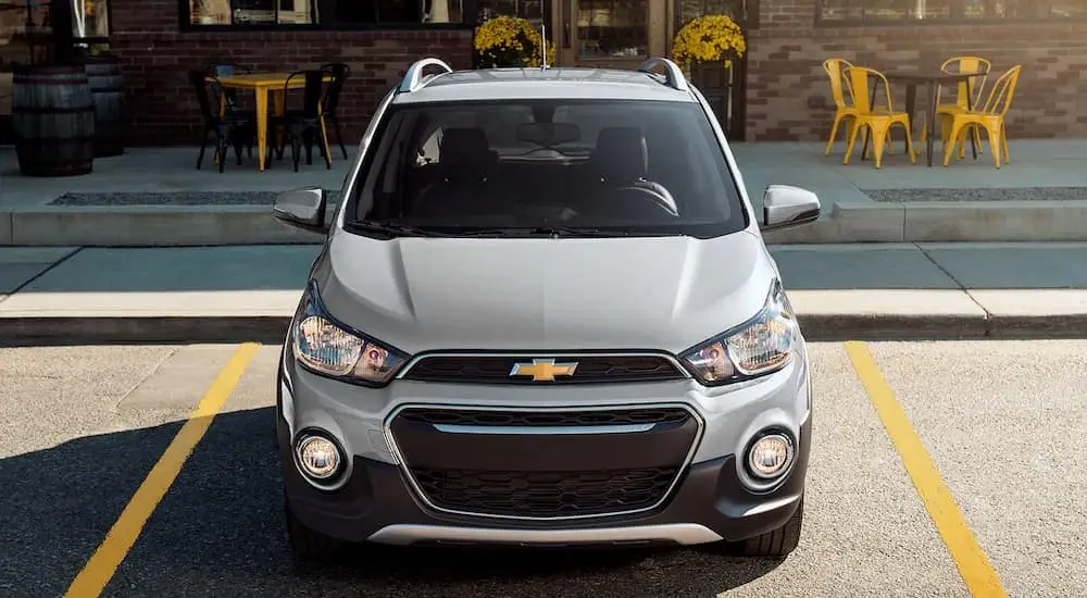 A silver 2022 Chevy Spark is shown from the front parked near a Selmer used Chevy dealer.