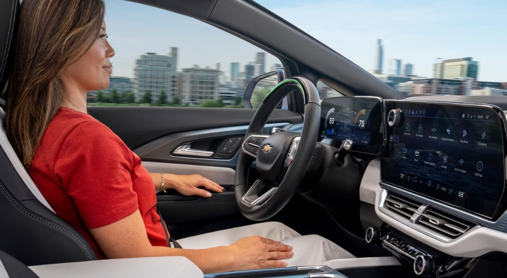 A person is shown using the Super Cruise feature in a 2025 Chevy Equinox EV.