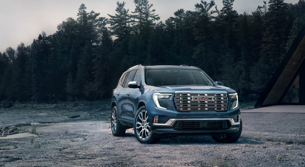 A blue 2024 GMC Acadia Denali is shown from the front at an angle.