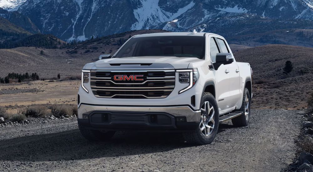 A white 2025 GMC Sierra 1500 SLT parked near mountains. 