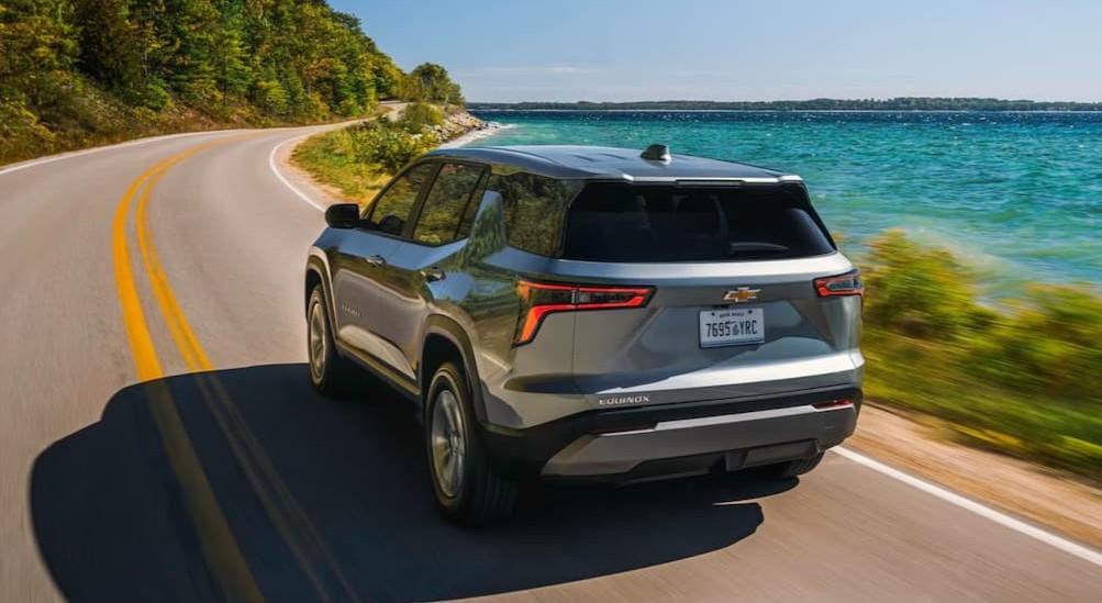 A silver 2026 Chevy Equinox for sale driving on a highway.