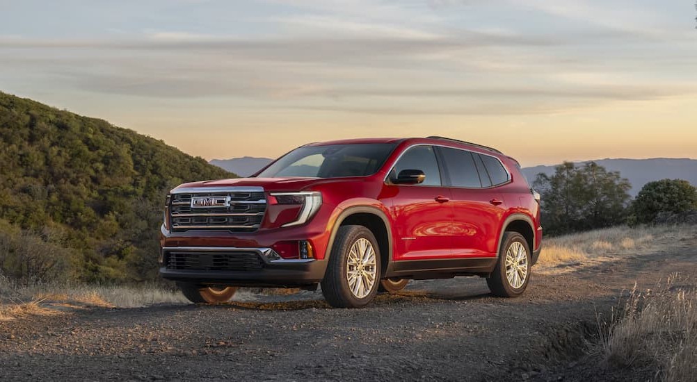 A red 2025 GMC Acadia for sale near New Albany parked off-road.