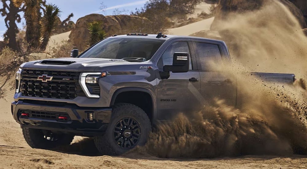 Grey 2024 Chevy Silverado 2500 HD ZR2 driving through a desert.