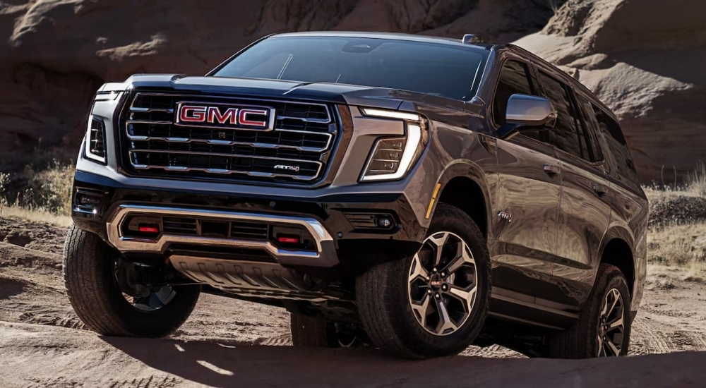 A black 2025 GMC Yukon AT4 off-roading on sand