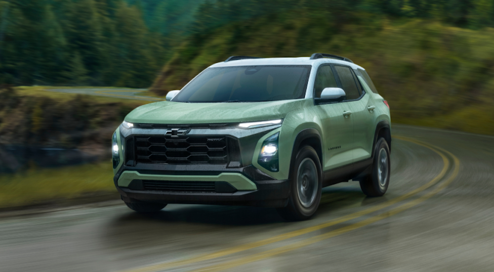 Green 2026 Chevy Equinox ACTIV driving around a bend.