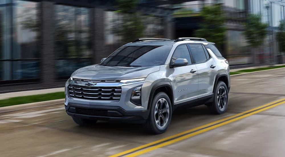 Silver 2026 Chevy Equinox driving down a road.