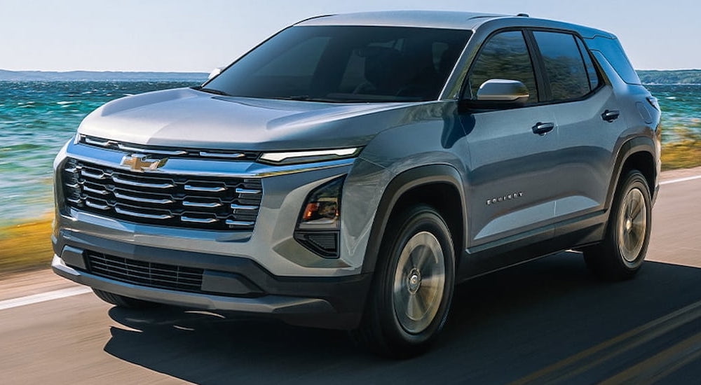 Silver 2026 Chevy Equinox driving down a road.