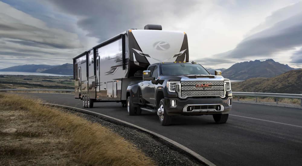 A black 2021 GMC Sierra 3500 towing a camper