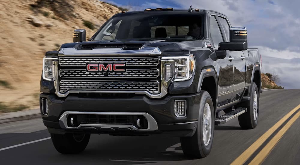 A black 2023 GMC Sierra 2500 HD Denali driving down a highway