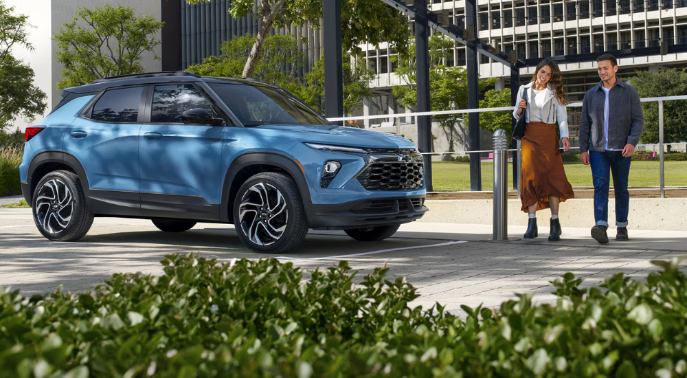 A couple walks to a blue 2026 Chevy Trailblazer for sale