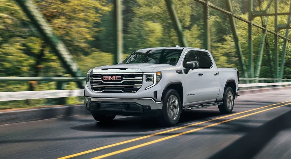 A white 2026 GMC Sierra 1500 driving to a GMC dealer near Olive Branch.