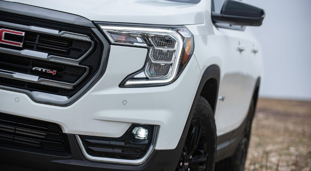 A close-up shows the driver side headlight on a white 2022 GMC Terrain AT4.