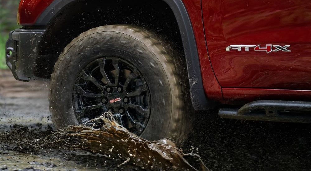 Black rim on a 2023 GMC Sierra 1500 AT4X driving through mud