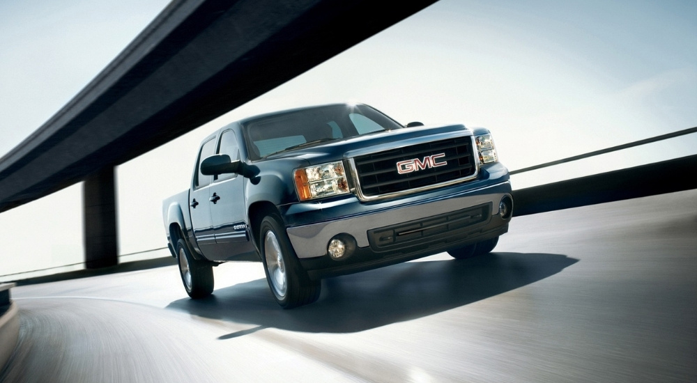 Blue 2008 GMC Sierra 1500 driving past a bridge
