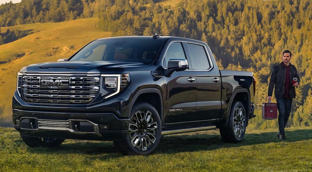 A black 2023 GMC Sierra 1500 Denali Ultimate for sale is shown parked off-road.