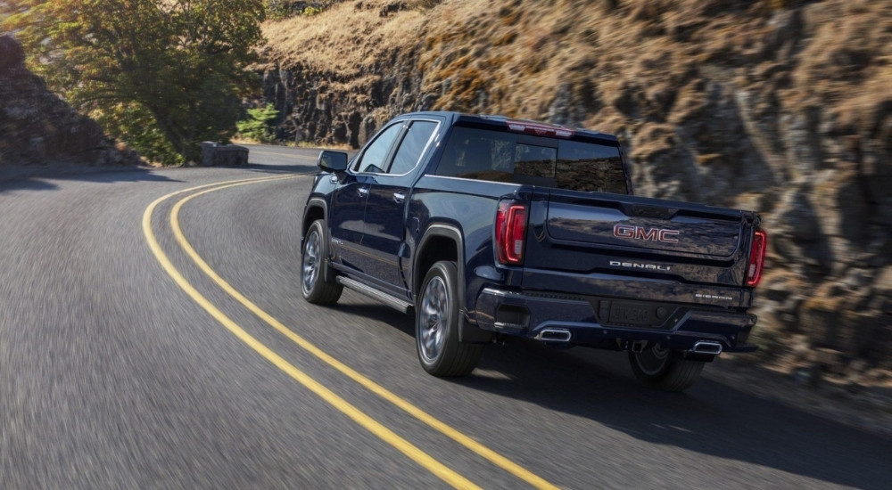 Black 2024 GMC Sierra 1500 Denali rounding a bend