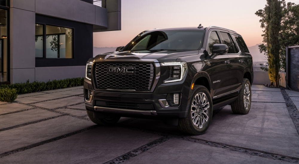A black 2024 GMC Yukon XL Denali is shown parked on a driveway.