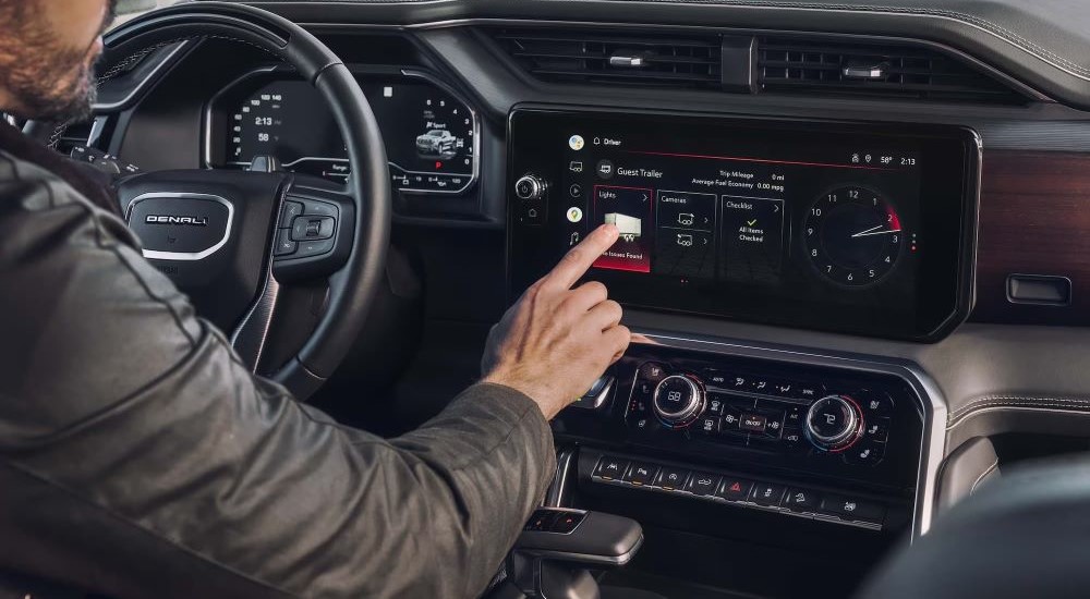 Person using the infotainment screen in a 2024 GMC Sierra 1500 Denali