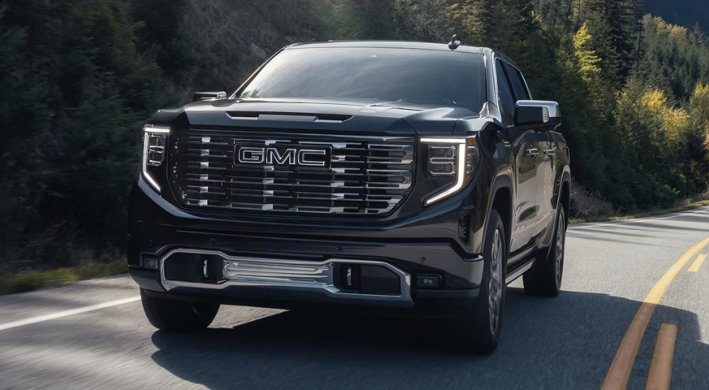 A black 2025 GMC Sierra 1500 Denali is driving on a highway.
