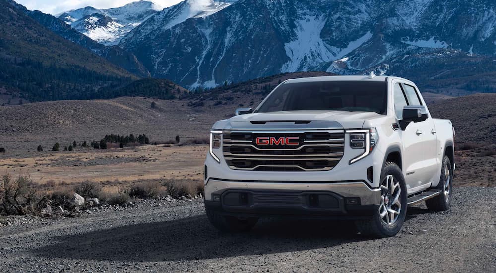 A white 2025 GMC Sierra 1500 SLT parked near mountains. 