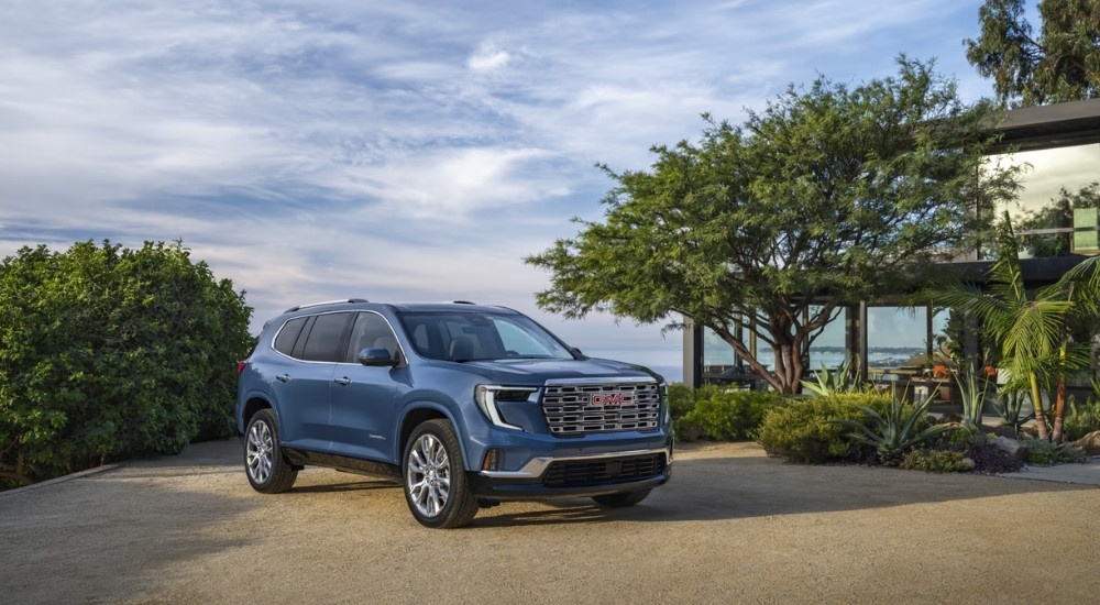 Blue 2025 GMC Acadia parked in a driveway.