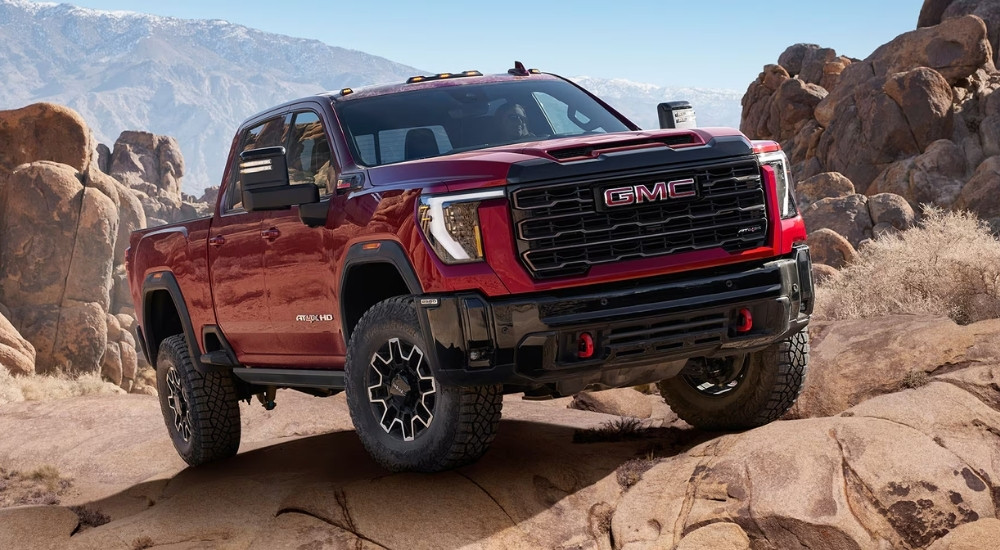 A red 2025 GMC Sierra 2500 AT4X parked off-road.
