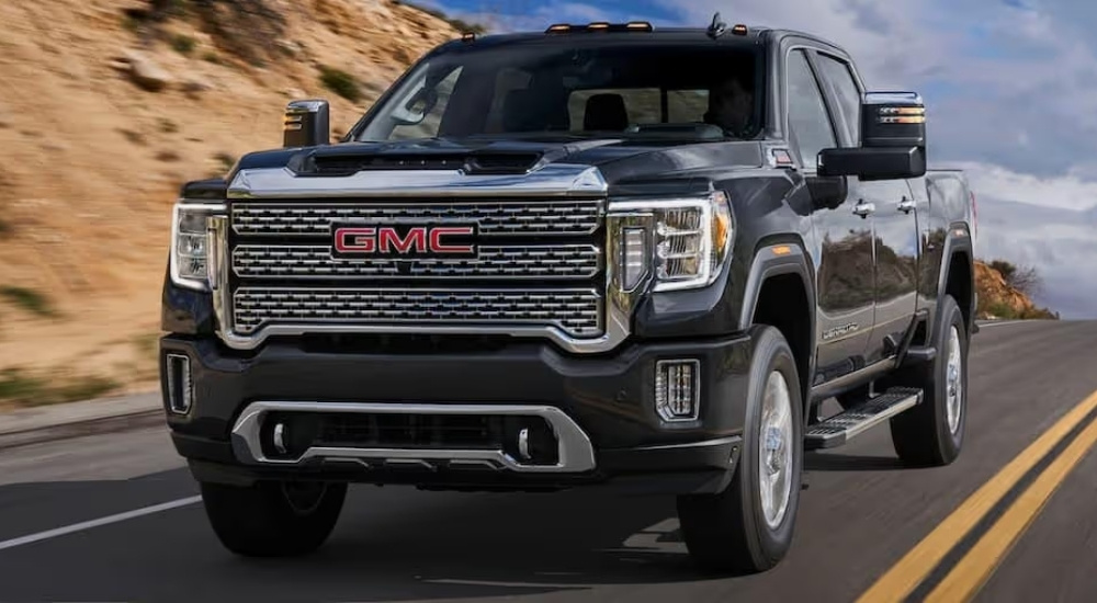 A black 2023 GMC Sierra 2500 HD Denali driving down a highway