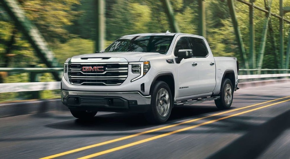 A white 2026 GMC Sierra 1500 driving to a GMC dealer near Olive Branch.