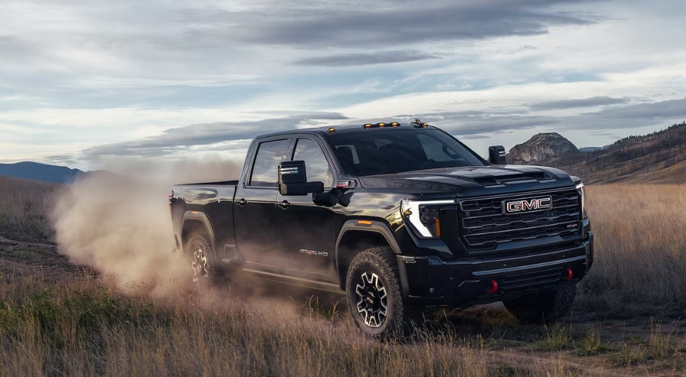 A black 2026 GMC Sierra 2500 HD AT4X driving off-road.