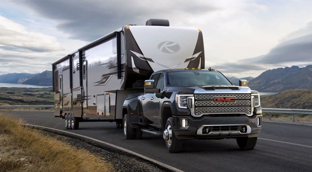A black 2020 GMC Sierra 3500 HD Denali is sown towing a trailer after looking at used GMC trucks.