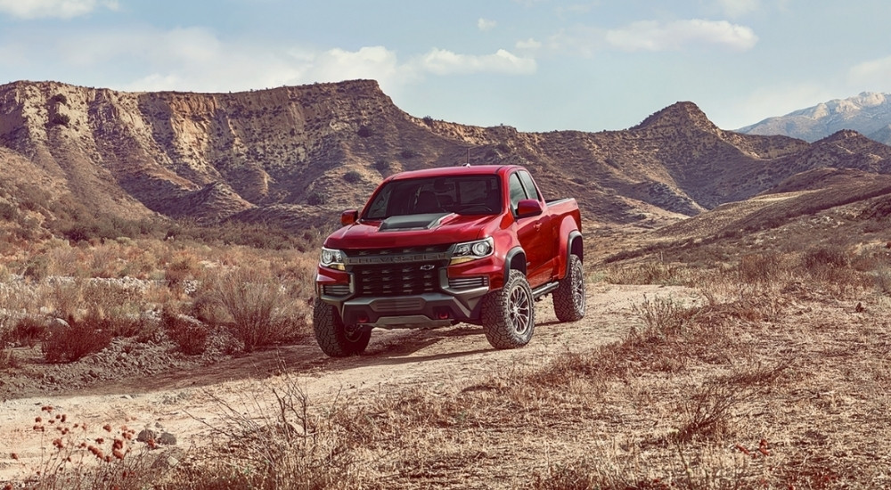 A red 2021 Chevy Colorado ZR2 is shown from the front at an angle after leaving a dealer that has used trucks for sale.