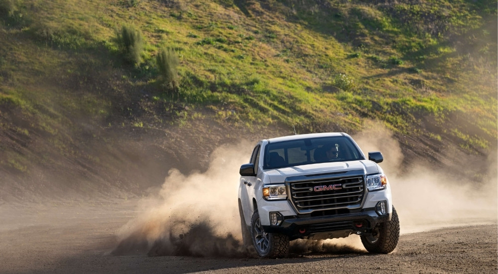 White 2022 GMC Canyon AT4 kicking up dust