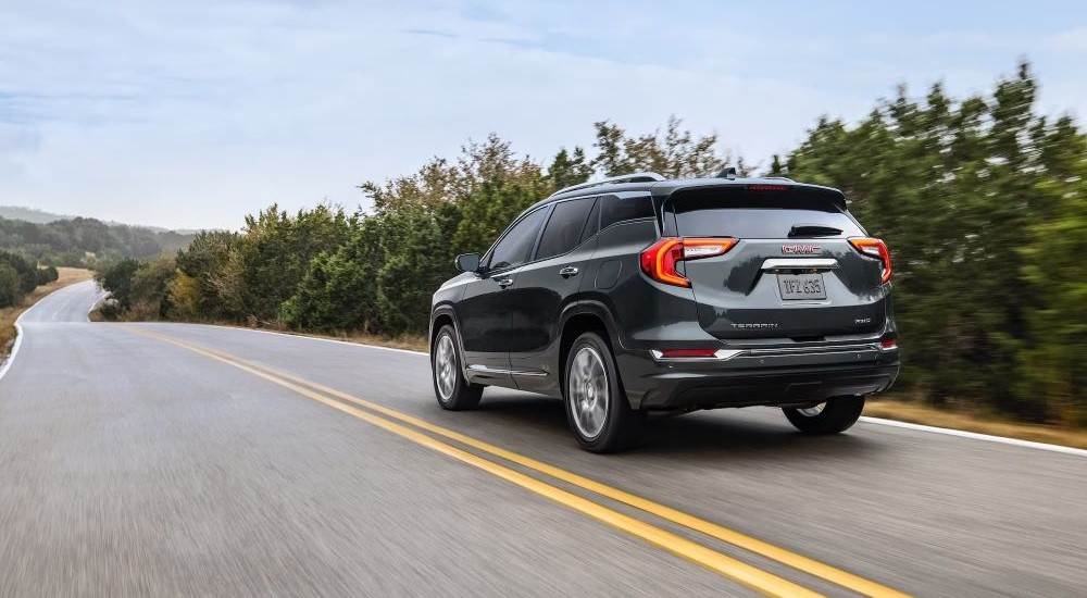 A grey 2022 GMC Terrain Denali is shown from the rear after leaving a used GMC dealer.