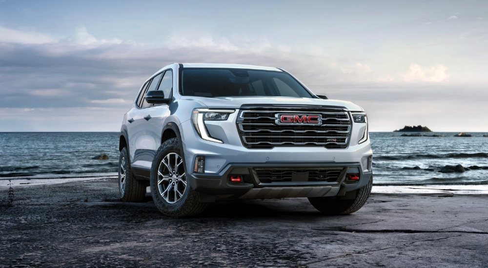 white 2024 GMC Acadia AT4 is shown from the front at an angle.