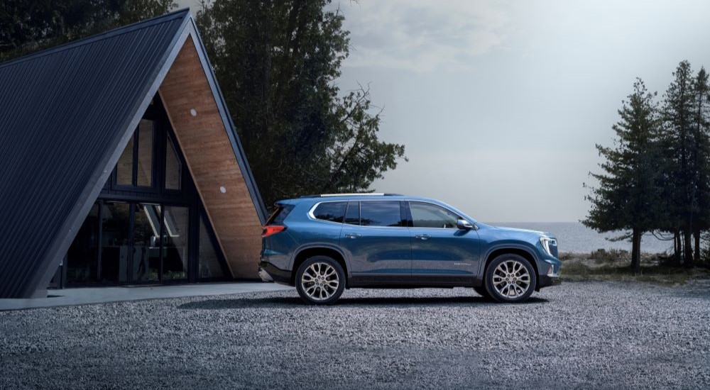 A blue 2024 GMC Acadia Denali is shown from the side after leaving a GMC Acadia dealer.