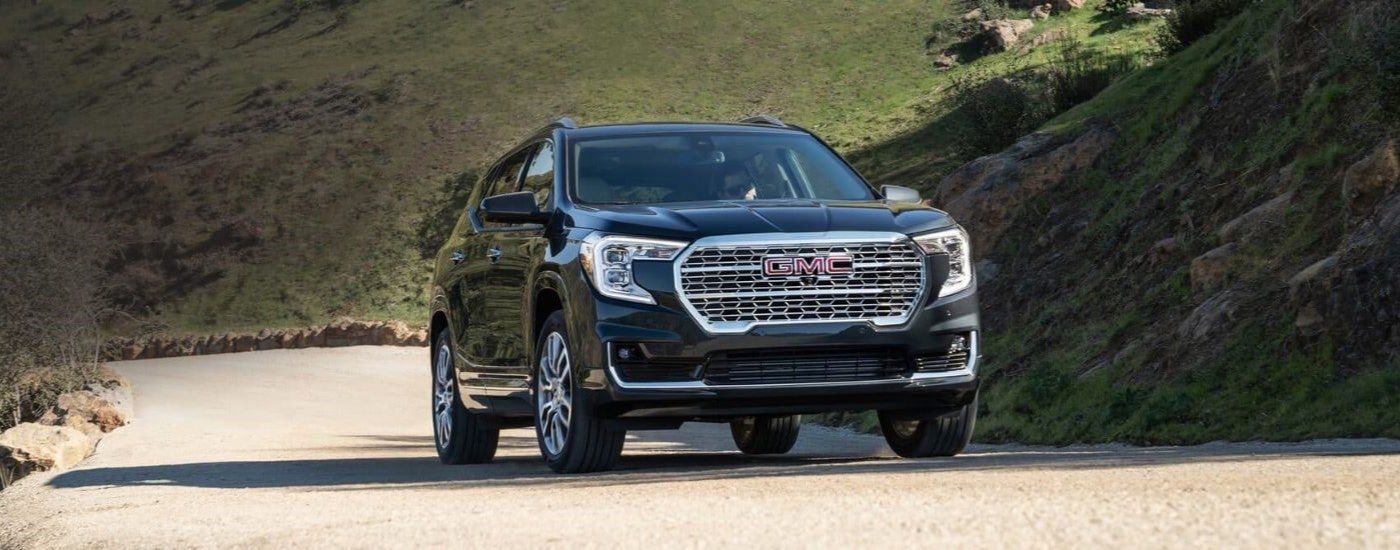 Black 2022 GMC Terrain Denali driving to a GMC dealer near Tupelo