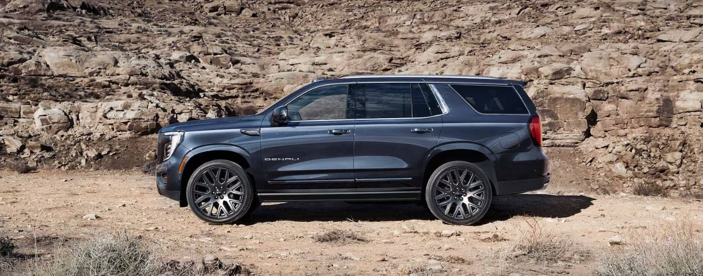 Black 2025 GMC Yukon Denali driving on a trail