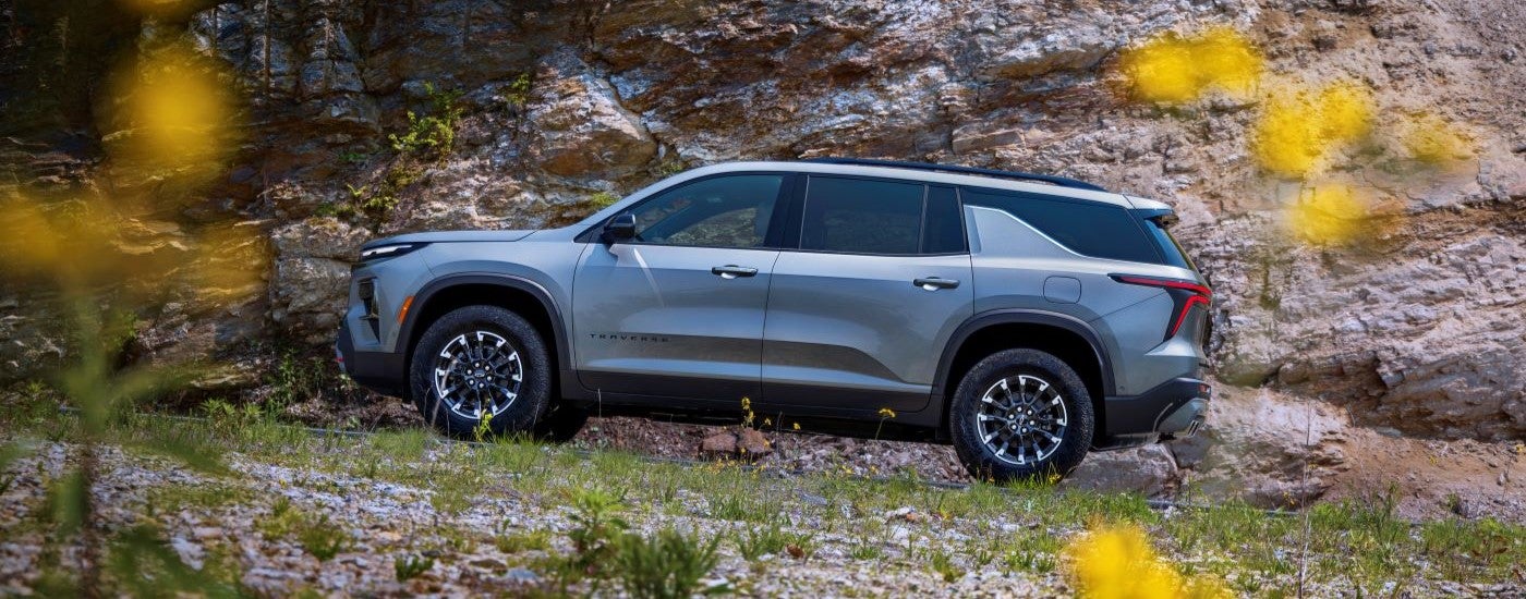 Side angle view of a grey 2024 Chevy Traverse Z71 parked on a flower field.