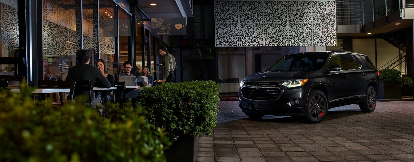 A black 2021 Chevy Traverse Red Line is shown outside of a restaurant.