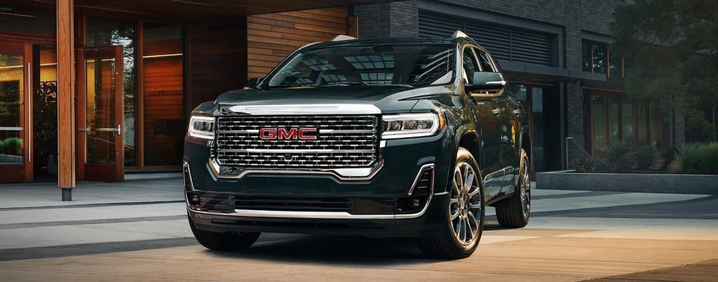 A black 2023 GMC Acadia Denali is shown parked on a driveway.