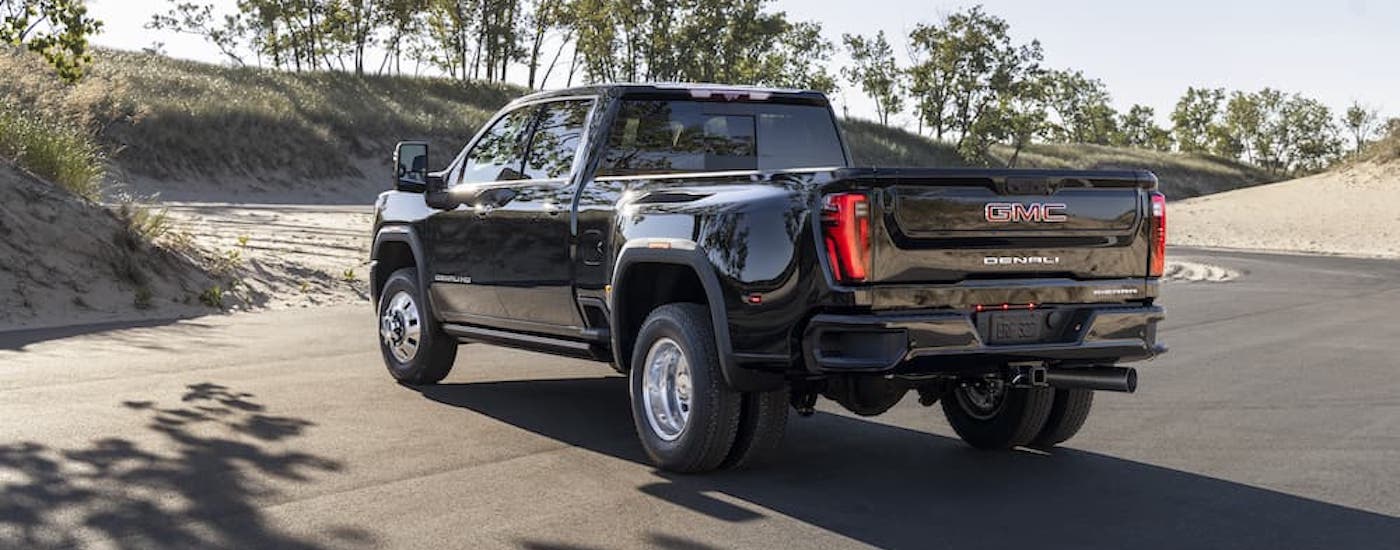 A black GMC Sierra 3500 HD Denali is shown from the rear at an angle.