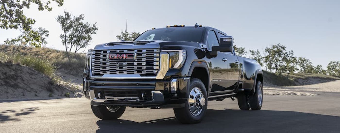 A black 2024 GMC Sierra 3500 HD Denali is shown from the front at an angle.