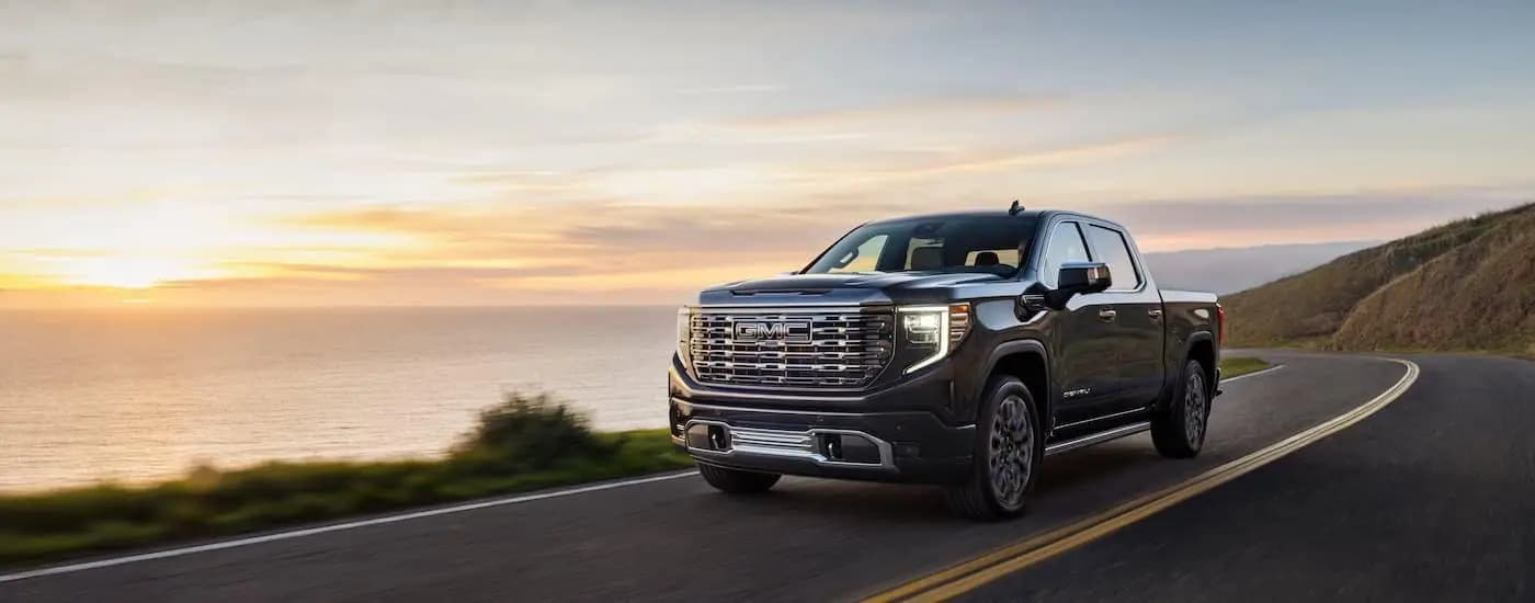 A black 2024 GMC Sierra 1500 Denali Ultimate is shown from the front at an angle.