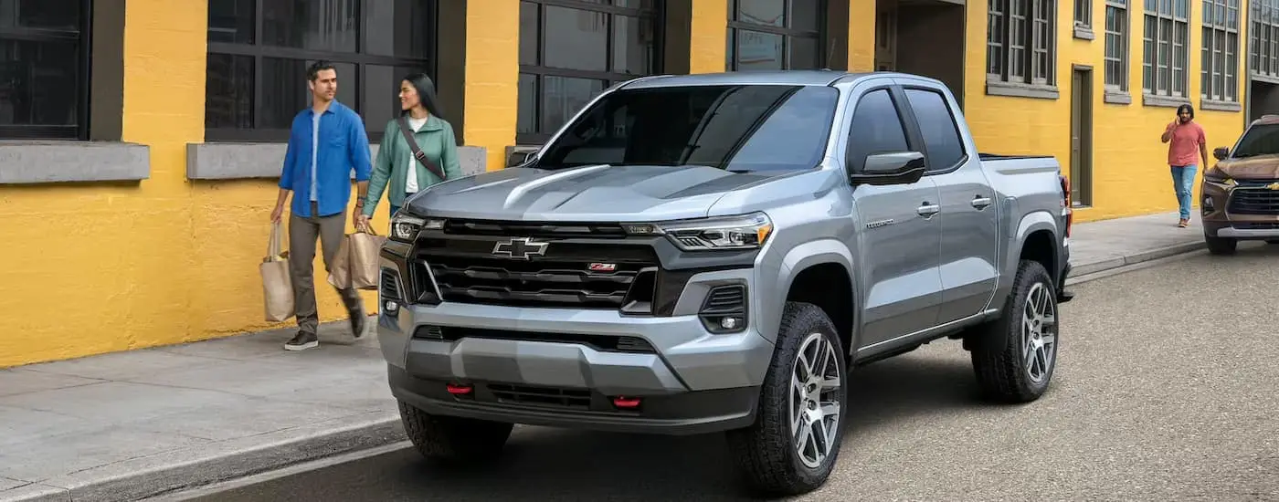  A silver 2023 Chevy Colorado Z71 is shown parked on the side of a city street.