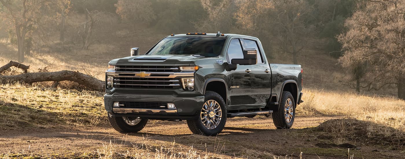 A silver 2020 Chevy Silverado 2500HD parked at a ranch after leaving a used Chevy truck dealership.