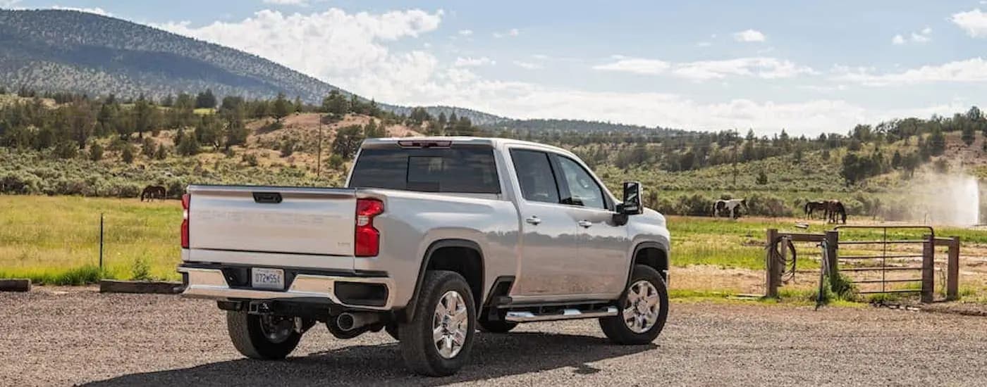 A silver 2022 Chevy Silverado 2500 HD is shown from the rear at an angle.