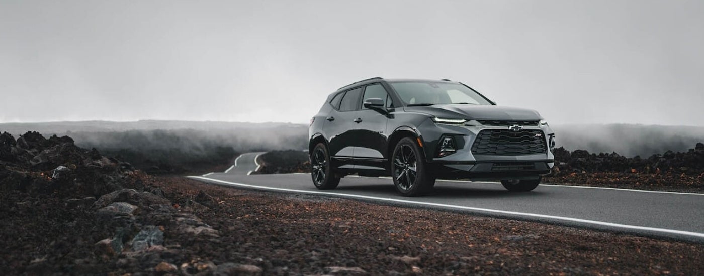 A grey 2020 Chevy Blazer RS is parked on a misty road after visiting a used GM dealership.